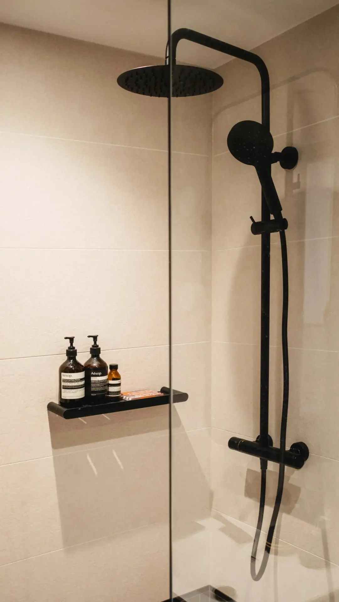 Black shower fittings in a tiled London bathroom