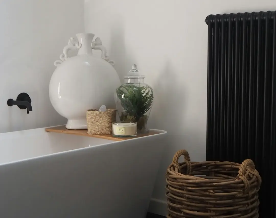 Black radiator beside a bath in a UK bathroom